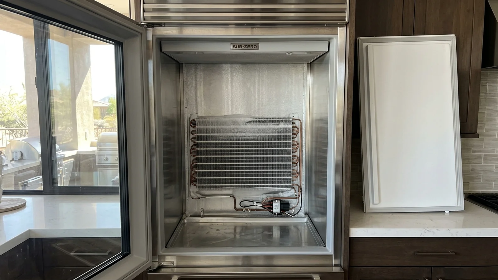 Open Sub-Zero built-in refrigerator column showing the interior compartment during a repair visit